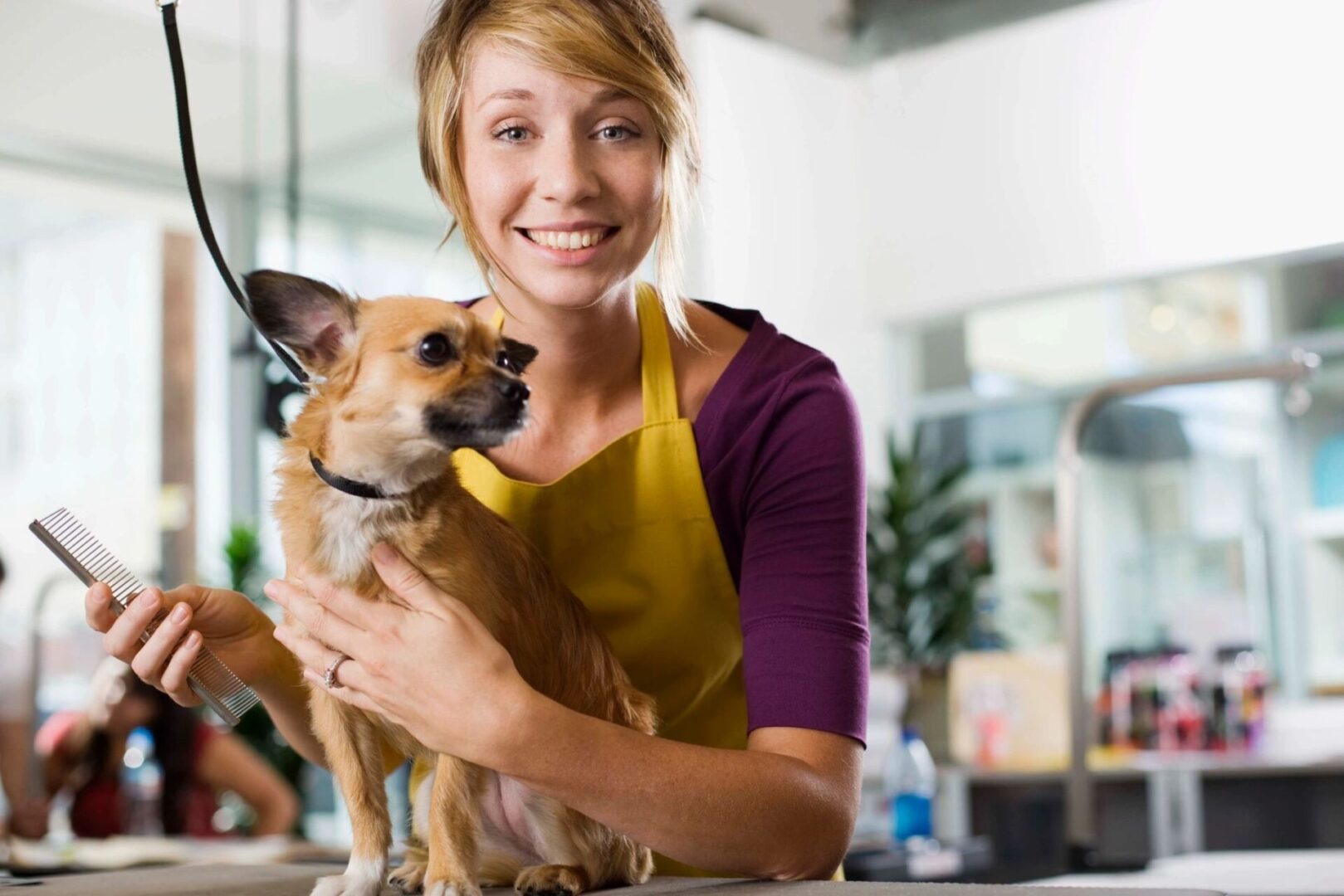 A woman holding a dog in her arms.